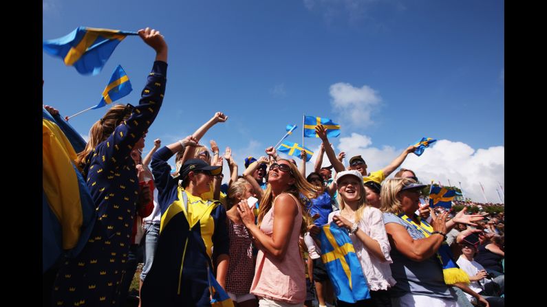 Supporters of Fredrik Loof and Max Salminen of Sweden celebrate as the sailors take overall victory following the men's star sailing medal race.
