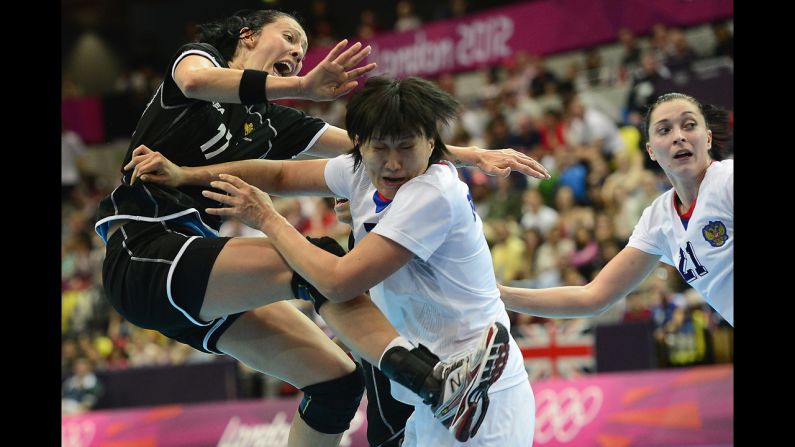 Montenegro's Bojana Popovic, left, vies with Russia's Liudmila Bodnieva, center, during a women's preliminary handball match.