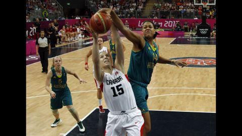 Canadian forward Michelle Plouffe, center, struggles with Australian center Elizabeth Cambage for control of the ball during the women's preliminary round group B basketball match.