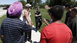 Bystanders look on as officer surrand the Sikh Temple of Wisconsin.