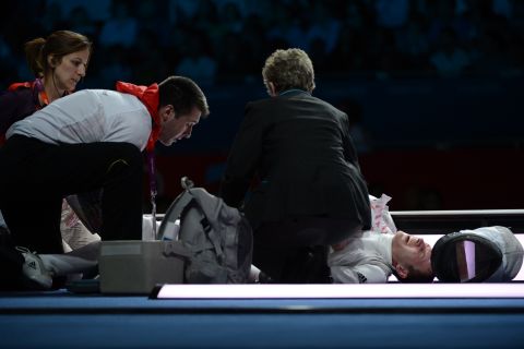 Germany's Sebastian Bachmann is treated by medical personnel after being injured during his bout with U.S. fencer Gerek Meinhardt during the men's foil team medal bronze match.
