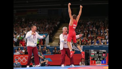 Peter Modos of Hungary jumps for joy after winning the men's Greco-Roman 55-kilogram wrestling bronze medal bout against Haakan Erik Nyblom of Denmark.