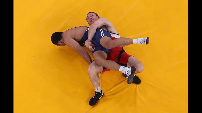 Aliaksandr Kikiniou of Belarus, in red, grapples with Emin Ahmadov of Azerbaijan in their men's Greco-Roman 74-kilogram wrestling bronze medal match.