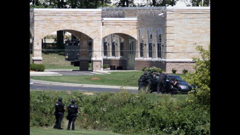 SWAT officers gather in front of the temple Sunday. The attack occurred about 10:30 a.m., when temple members were reading scriptures and cooking food.