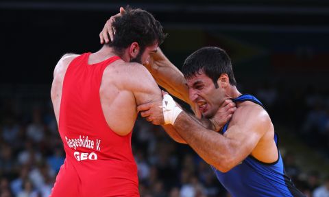 Vladimer Gegeshidze, left, of Georgia wrestles with Saman Tahmasebi of Azerbaijan during their men's Greco-Roman 84-kilogram wrestling 1/8 final bout Monday.