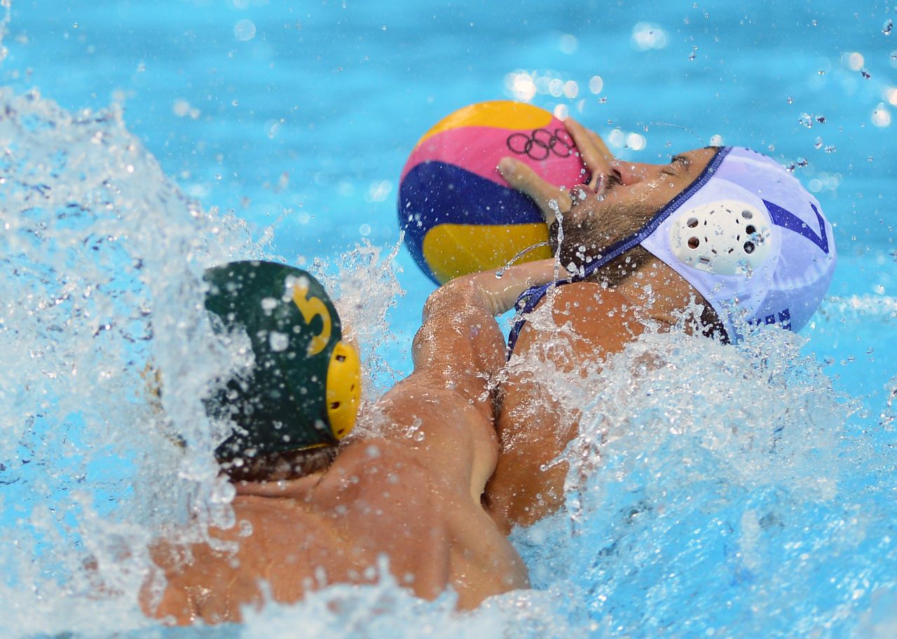 Greece's Christos Afroudakis, right, is challenged by Australia's Aaron Younger during the men's water polo preliminary round match at the Water Polo Arena.