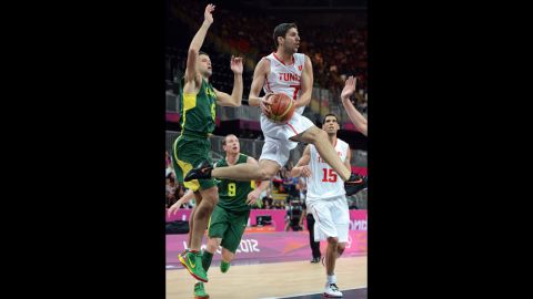 Tunisian guard Mourad El Mabrouk, center, leaps with the ball during the men's basketball preliminary round match against Lithuania.