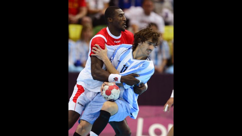 Tunisia's Selim Hedoui, lelft, collides with Argentina's Guido Riccobelli during the men's preliminary Group A handball match at the Copper Box hall.