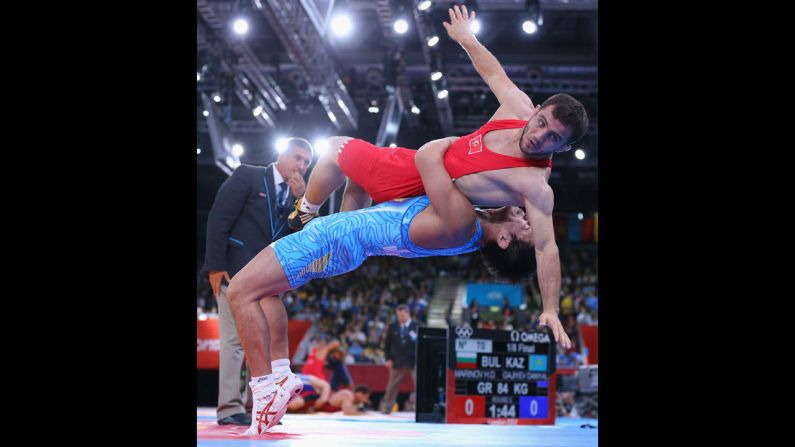 Rahman Bilici of Turkey, top, is taken down by Ryutaro Matsumoto of Japan during their men's Greco-Roman 60-kilogram wrestling 1/8 final bout.