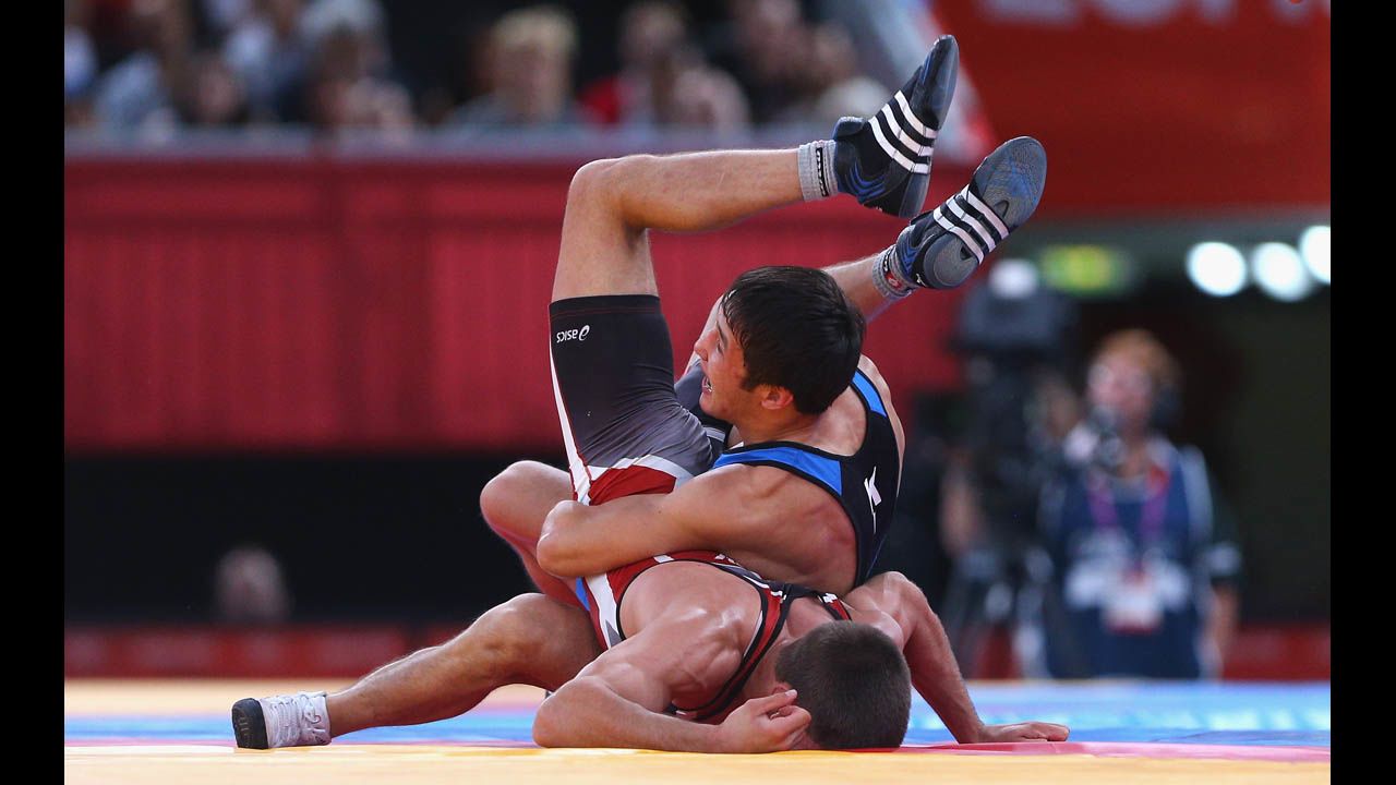 Ivo Serafimov Angelov of Bulgaria, bottom, competes against Almat Kebispayev of Kazakhstan, top, during the men's Greco-Roman 60-kilogram wrestling repechage.