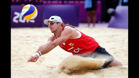 Mariusz Prudel of Poland attempts to hit a return against Emanuel Rego and Alison Cerutti of Brazil during the men's beach volleyball quarterfinal match.