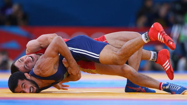 Zaur Kuramagomedov of Russia, in red, competes with Hasan Aliyev of Azerbaijan, in blue, during their men's Greco-Roman 60-kilogram wrestling bronze medal bout.