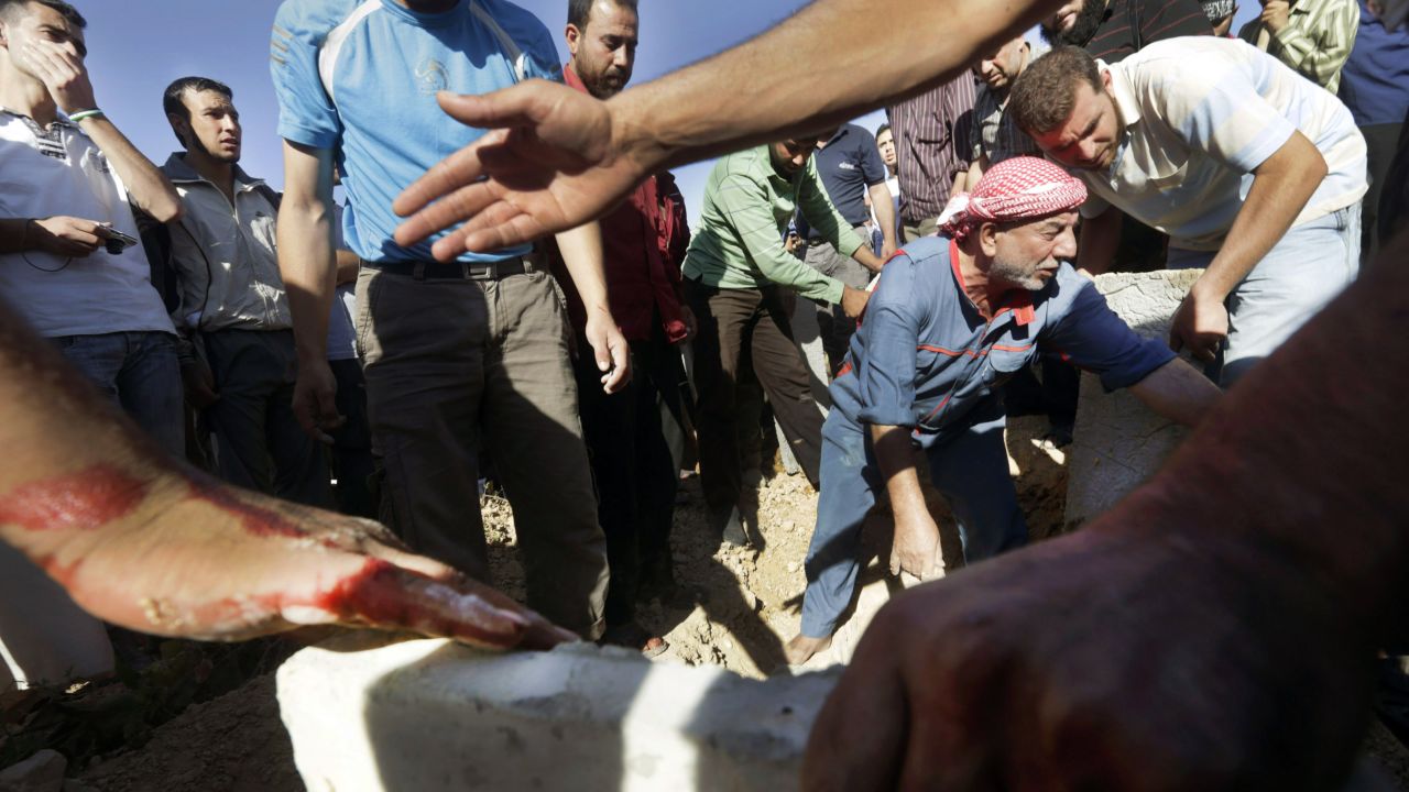 Syrian men bury their dead following heavy shelling by Syrian government forces in Qusayr, close to Homs, on July 3.
