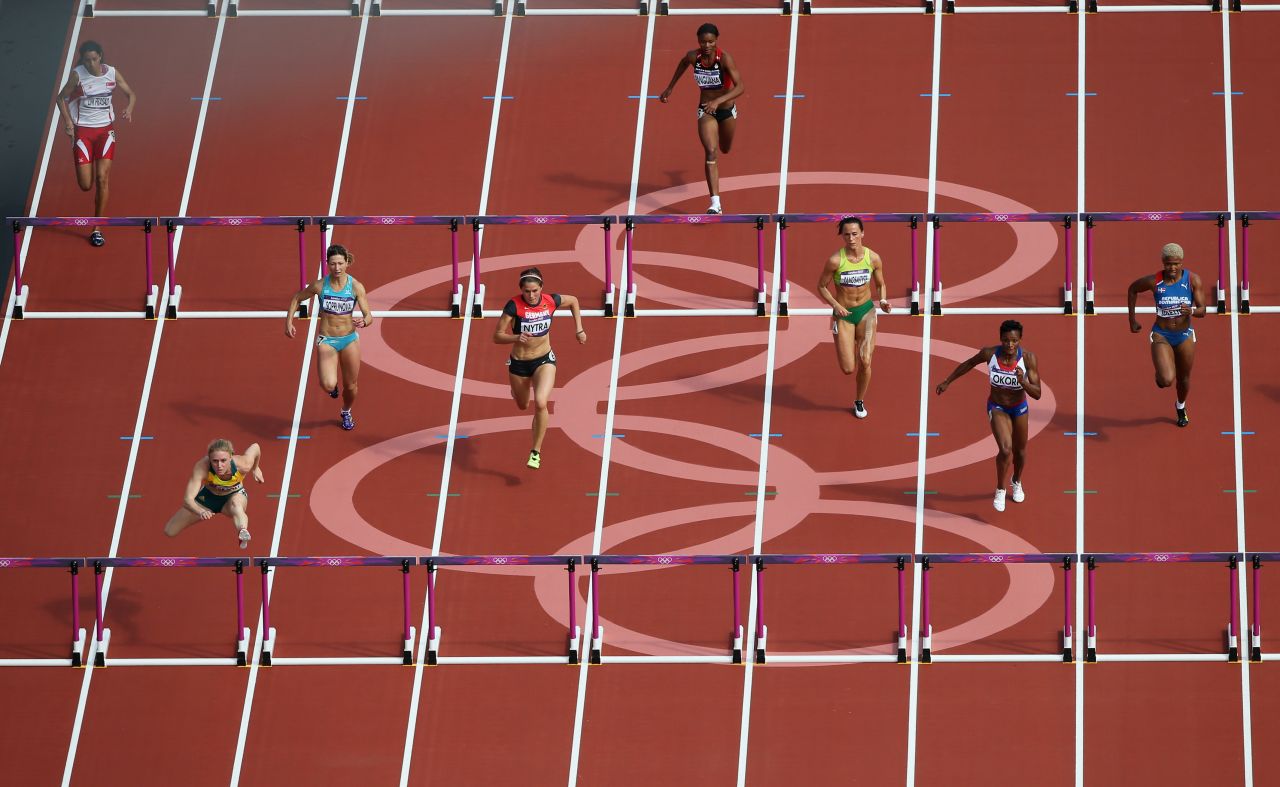 Athletes compete in the women's 100-meter hurdles at Olympic Stadium.