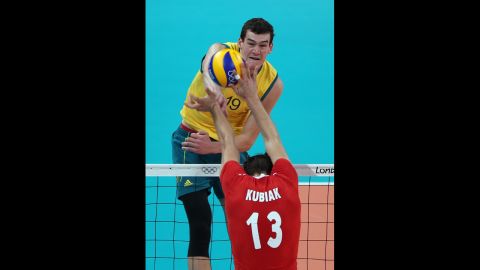 Thomas Edgar of Australia spikes the ball over Michal Kubiak of Poland during men's volleyball match at Earls Court.