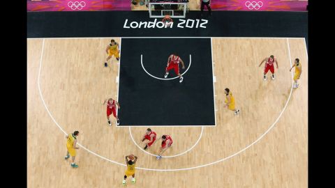 Australia, in yellow, and Russia face off in the final seconds of the men's basketball preliminary round match.