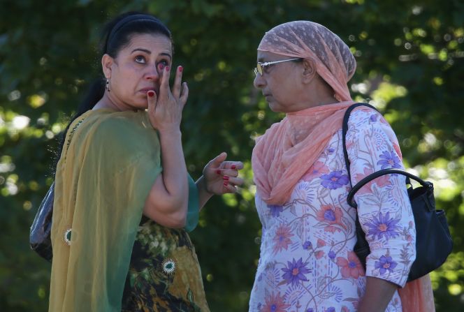 A woman wipes away a tear outside the Sikh temple.