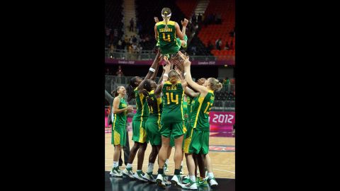 No. 4 Adriana Pinto is thrown into the air by teammates to honor her final game with the Brazil National Team after the women's basketball preliminary round match against Great Britain.