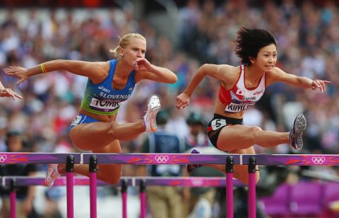 Marina Tomic, left, of Slovenia and Ayako Kimura of Japan compete in the women's 100-meter hurdles Monday.