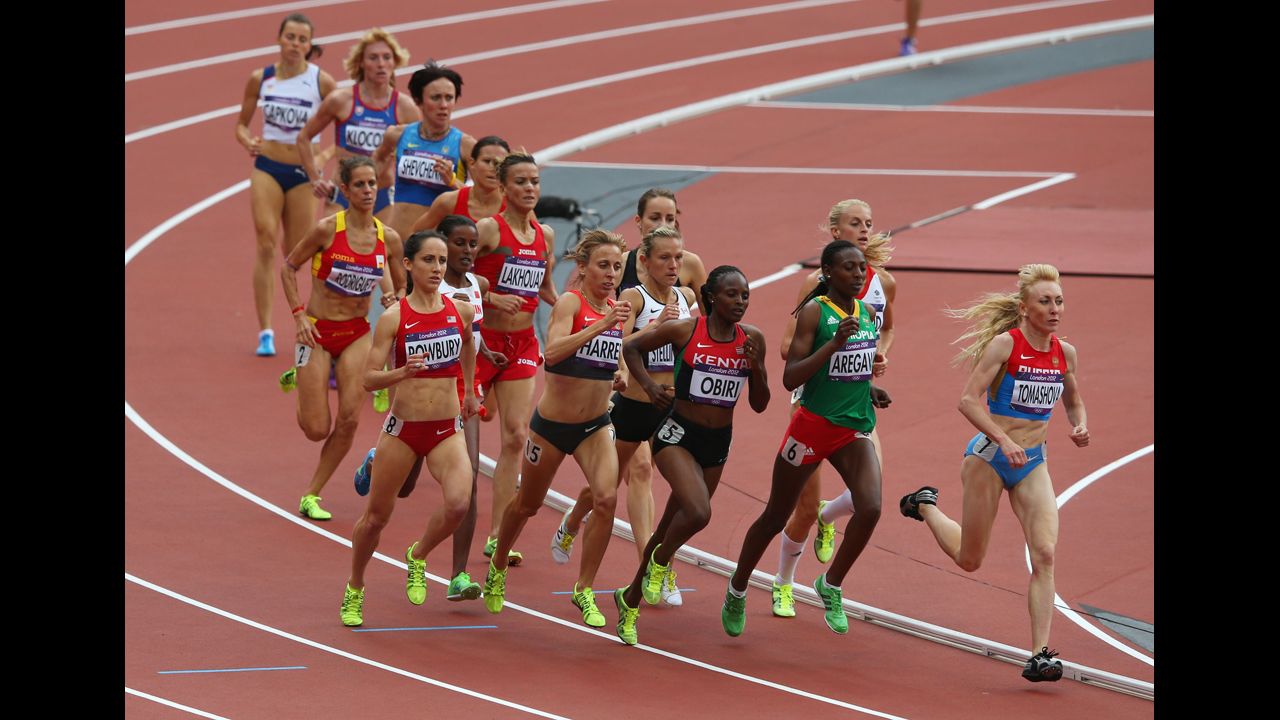 Runners round a turn in the women's 1,500-meter heat Monday.