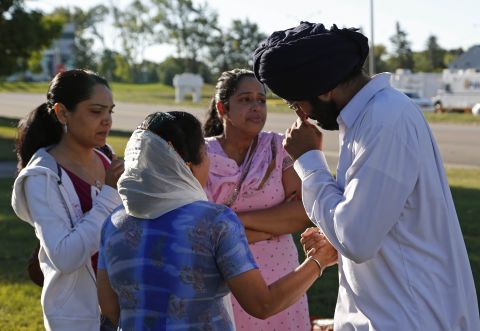 People console each other on Monday at the command center near the Sikh Temple of Wisconsin.