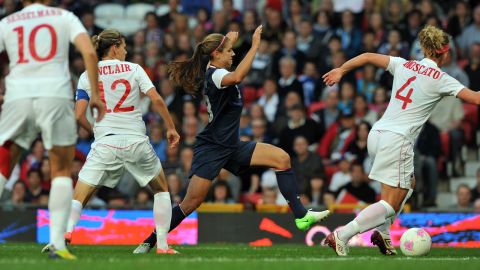 U.S. forward Alex Morgan, center in blue, runs with the ball past Canada's defender Lauren Sesselmann, number 10,  forward Christine Sinclair, number 12, and defender Carmelina Moscato, number four, during the women's soccer semifinal match on Day 10 of the London Olympic Games on Saturday, August 4.  Check out <a href="http://www.cnn.com/2012/08/05/worldsport/gallery/olympics-day-9/index.html" target="_blank">Day 9 of competition</a> from Sunday, August 5. 