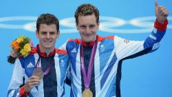 Alastair Brownlee (R) and brother Jonny pose with their medals after the men's triathlon