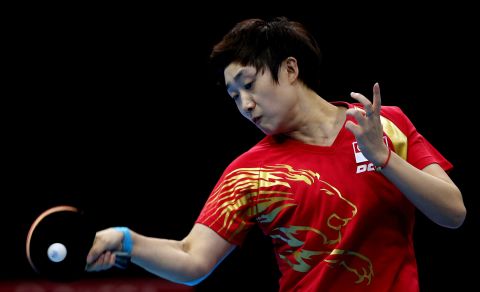Tianwei Feng of Singapore competes in the women's team table tennis bronze medal match.