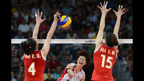 Japan's Saori Kimura, center, spikes as China's Hui Ruoqi and Ma Yunwen attempt to block during the women's quarterfinal volleyball match.