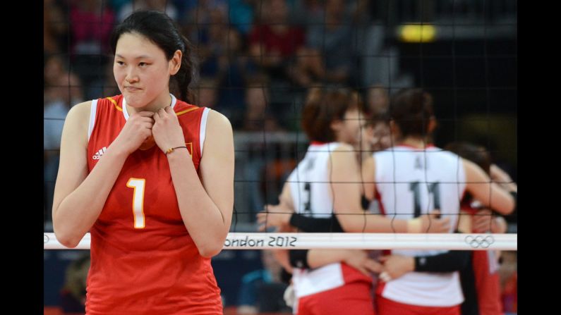 Chinese volleyball player Wang Yimei reacts as the Japanese team celebrates after it won the third set women's quarterfinal match. Japan won in five sets.
