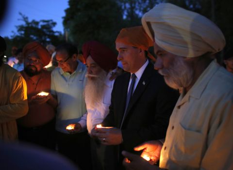 Wisconsin Gov. Scott Walker, along with members of the Sikh community, attends Monday's vigil at the Sikh Religious Society of Wisconsin for the victims of the shooting at the Sikh temple.