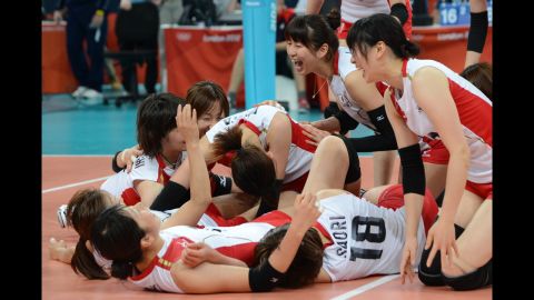 Japan's players celebrate their victory in the women's quarterfinal volleyball match against China.