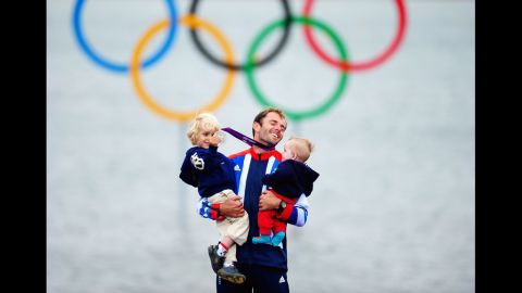 Silver medallist Nick Dempsey of Great Britain celebrates with his children Thomas-Flynn, left, and Oscar after the men's RS:X sailing.