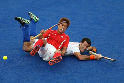 Hyo Sik You of South Korea falls on top of Marcel Balkestein of Netherlands during their men's field hockey match at Riverbank Arena Hockey Center.