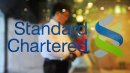 A man walks past a logo of Standard Chartered bank at the headquarters of SC First Bank in Seoul on June 27, 2011.