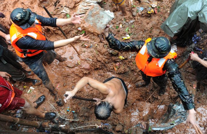 Rescuers dig through the rubble of a landslide caused by flooding as they try to rescue victims in Quezon City in suburban Manila.