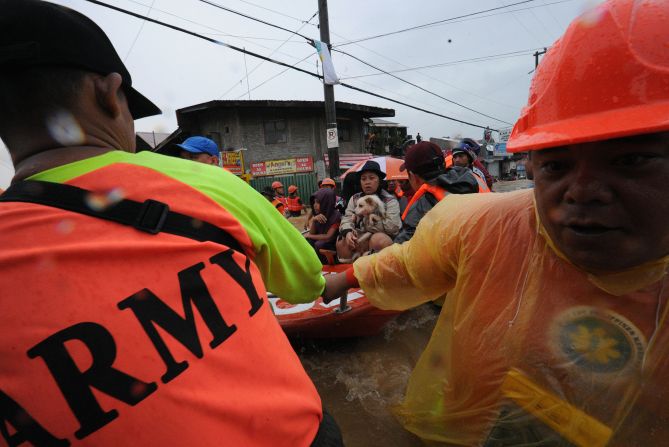 Rescue workers prepare to unload residents in the village of Tumana after their homes were flooded.