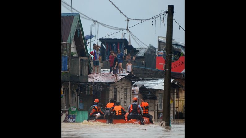 Rescuers in rubber boats evacuate residents from their homes in Tumana. 
