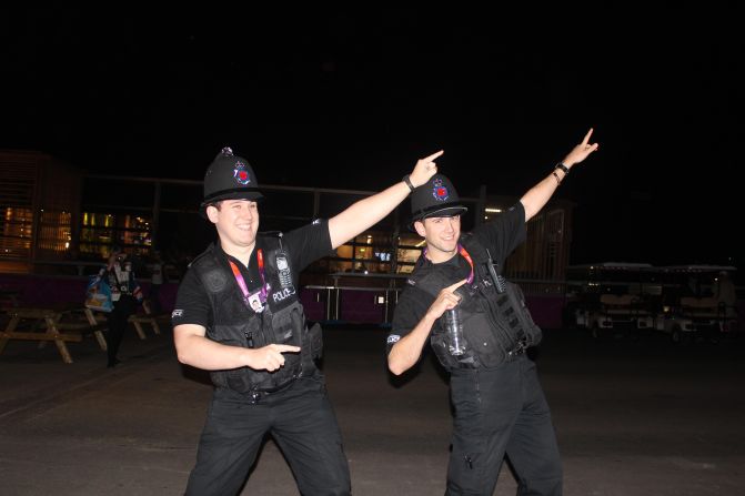 Two policemen at the Olympic Park celebrate Usain Bolt's victory in the 100 metres with his signature 'Bolt arms' salute. 