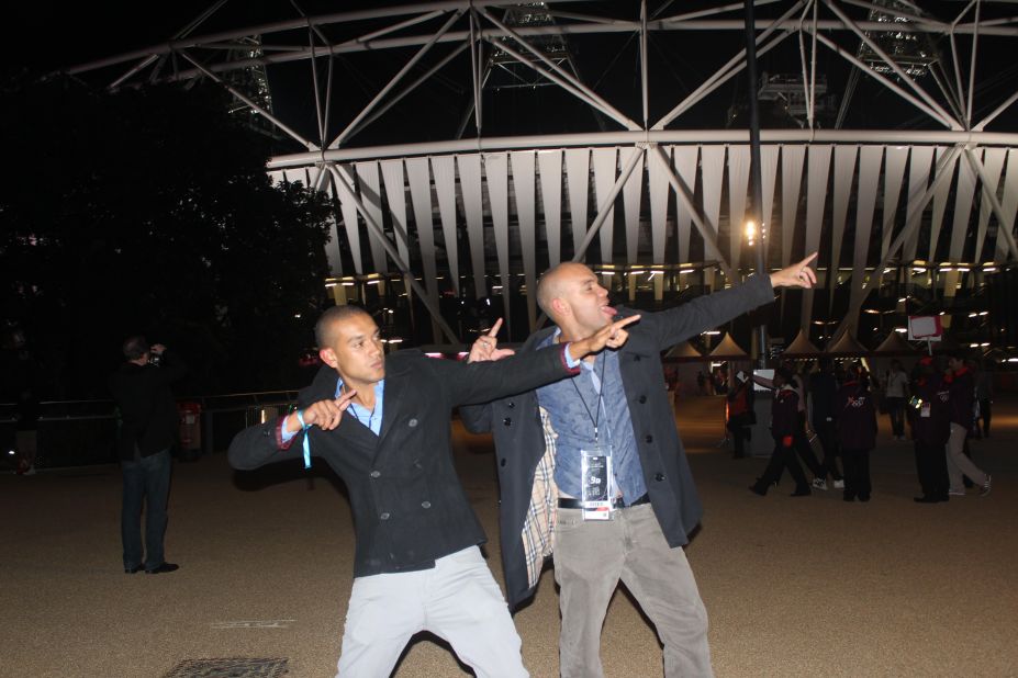 Two spectators outside the Olympic Park do their best Usain Bolt salutes.