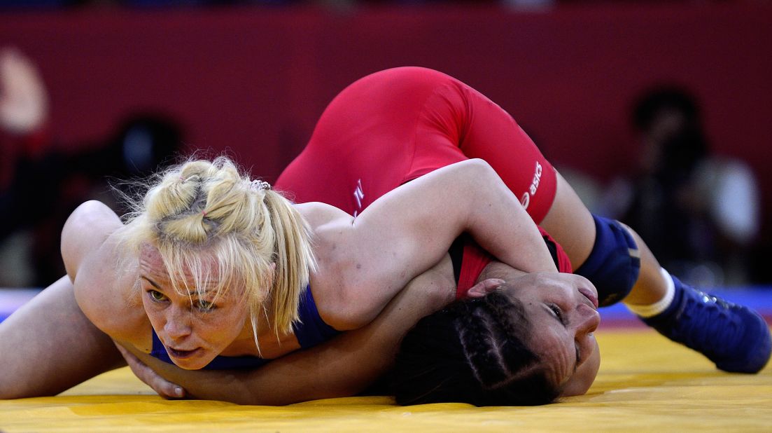 Ukraine's Irini Merleni, left, wrestles with Venezuela's Mayelis Yesenia Caripa Castillo during the women's 48-kilogram freestyle wrestling quarterfinal match.