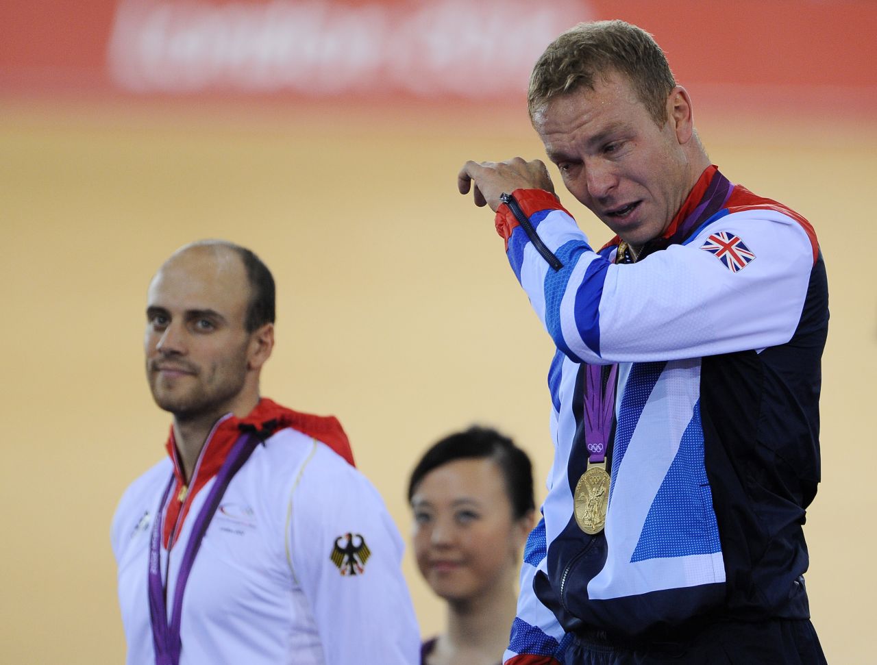 Gold medalist Sir Chris Hoy of Great Britain, right, tears up alongside silver medalist Maximilian Levy during the medal ceremony for the men's keirin track cycling final.