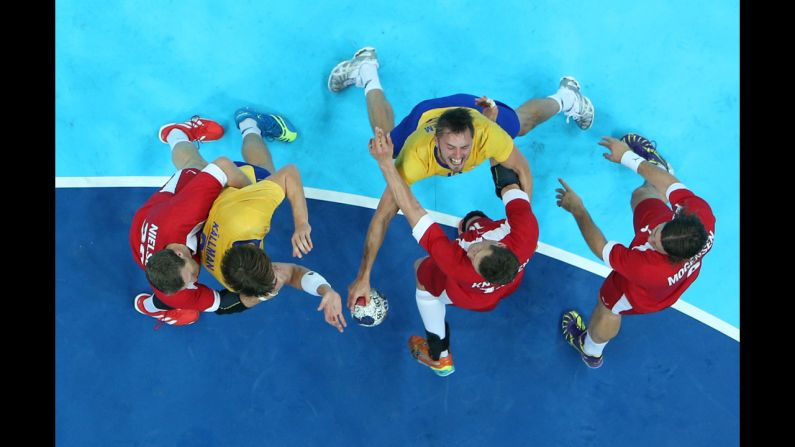 Sweden's Jonas Larholm fights through Danish handball players during the men's quarterfinal match. Sweden beat Denmark 24-22.