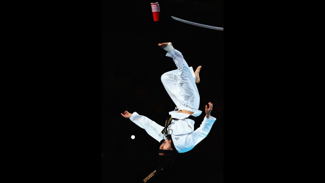A martial arts specialist performs stunts before the night session of taekwondo.