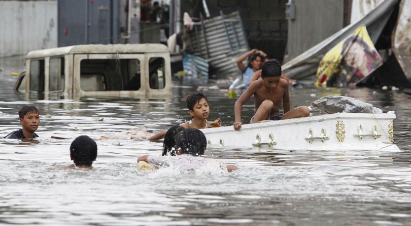 Residents use a coffin as a boat in floodwaters in Quezon city, Metro Manila.