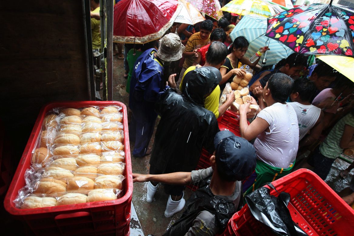 Filipino flood evacuees crowd around a truck giving out donated bread at an evacuation center in Marikina City, east of Manila.