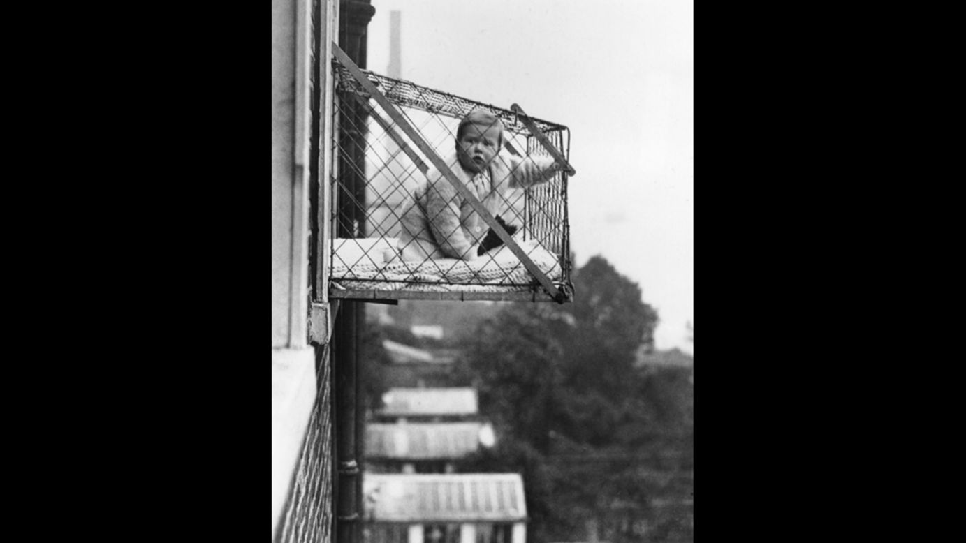 It's January 1934 and a baby sits in a wire cage suspended several stories about the street. East Poplar borough council planned to attach these fixtures to the outside of tenement windows so that the very young would be able to take fresh air and sunshine. It points to how both local and national government repeatedly tried to improve the lot of the largely working-class East London population throughout the 20th century. Whether this idea proved successful is not known (Getty Images).