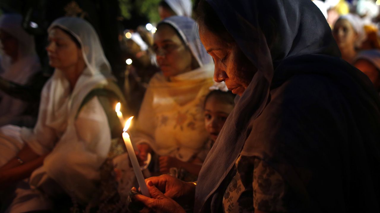 Mourners and supporters of the Sikh Temple of Wisconsin attend a candlelight vigil Tuesday at the Oak Creek Community Center.
