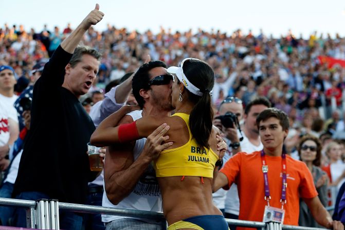 Juliana Silva of Brazil climbs into the crowd as she celebrates winning the women's beach volleyball bronze medal match against China.