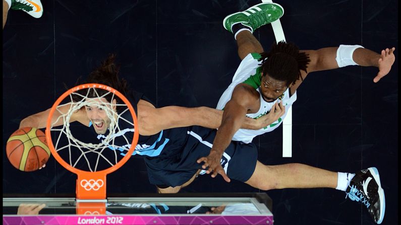 Argentinian forward Luis Scola, left, tries to score past Brazilian center Nene Hilario during the quarterfinal basketball match.